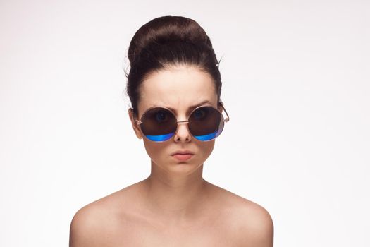 pretty woman naked shoulders sunglasses glamor light background. High quality photo