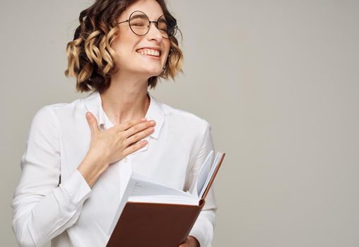 woman with notepad on gray background indoors gesturing with hands work office education. High quality photo