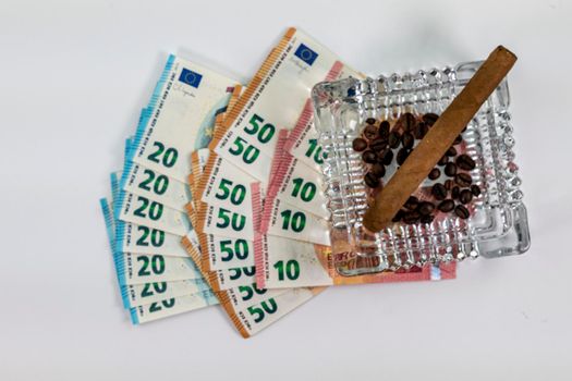 50 20 10 euro banknotes with ashtray and cigar on white background