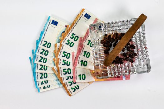 50 20 10 euro banknotes with ashtray and cigar on white background