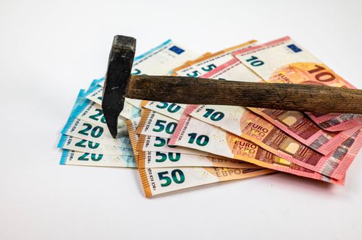 of 10 20 50 euro banknotes with work hammer on white background