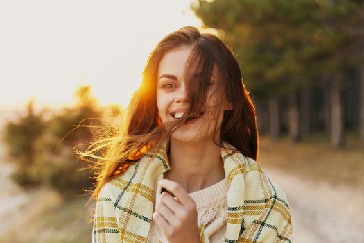 women near a coniferous forest with a blanket on their shoulders. High quality photo