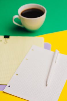 cup of coffee on a colored background and sheets of paper notepad office glasses. High quality photo