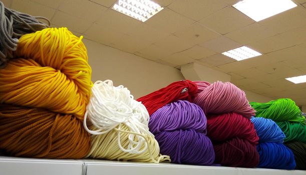 A bunch of colorful shoelaces. A bunch of colorful threads for sports shoes, lying on a shelf in the store.