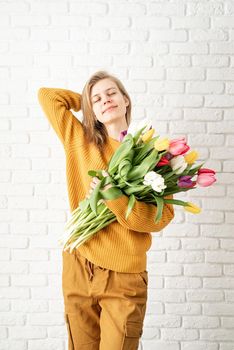 Mothers Day, Women's Day concept. Spring holidays. Happy young woman holding bouquet of tulips
