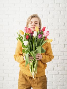 Mothers Day, Women's Day concept. Spring holidays. Happy young woman holding bouquet of tulips