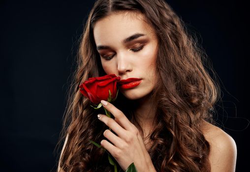 Romantic woman on a black background with a red flower. High quality photo