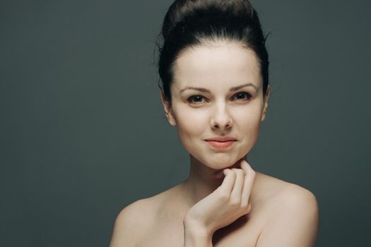pretty woman naked shoulders and clear skin charm dark background. High quality photo