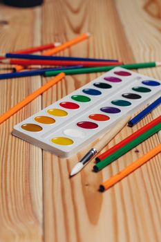 stationery colored pencils paint wooden table. High quality photo