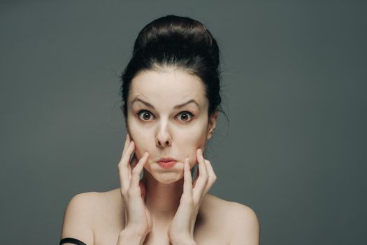 pretty woman grimacing on gray background cropped view portrait emotion. High quality photo