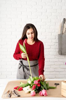 Valentine's Day and Women's Day. Small business. Woman florist making a bouquet of fresh colorful tulips