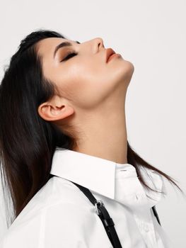 attractive brunette woman in white shirt looks up. High quality photo