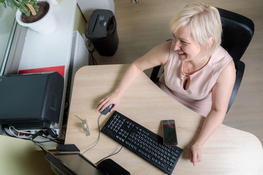 A female director working in an office is sitting at a table, analyzing business statistics, checking documents. Close-up.