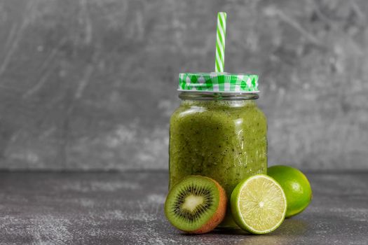 Step 5. Jar a mug with ready-made banana, kiwi and spinach smoothie with apple juice. Fresh citrus fruits and kiwis lie next to the jar