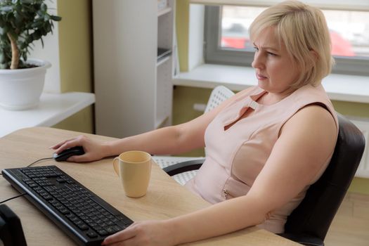 A female director working in an office is sitting at a table, analyzing business statistics, checking documents. Close-up.