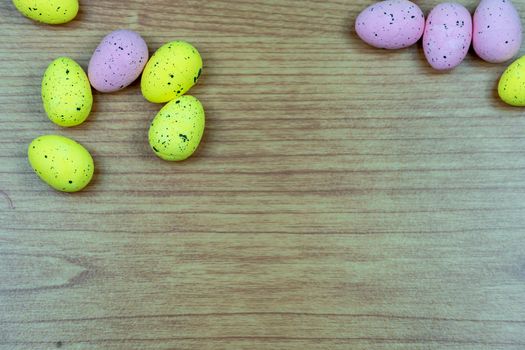 Closeup shot of Colorful yellow and pink easter egg placed on top of a wooden table