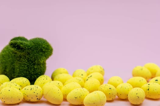Yellow Easter Egg with freckles pattern and Rabbit Bunny on Pink Background