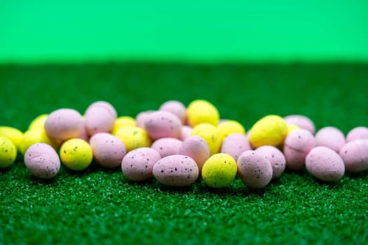 Colorful Yellow and Pink easter egg with freckle patterns on grass