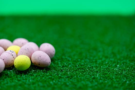 Colorful Yellow and Pink easter egg with freckle patterns on grass