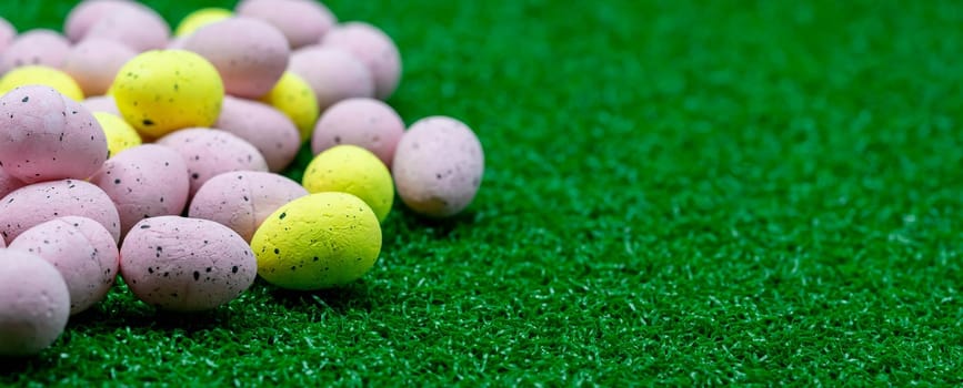 Colorful Yellow and Pink easter egg with freckle patterns on grass