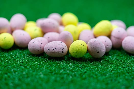 Colorful Yellow and Pink easter egg with freckle patterns on grass
