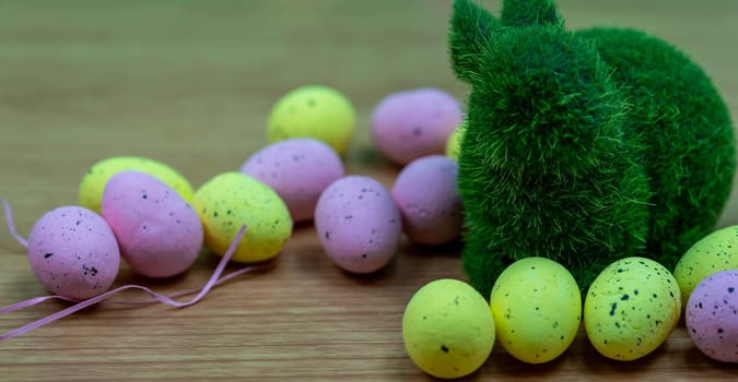 Closeup shot of Colorful yellow and pink easter egg placed on top of a wooden table