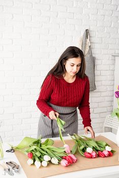 Valentine's Day and Women's Day. Small business. Woman florist making a bouquet of fresh colorful tulips