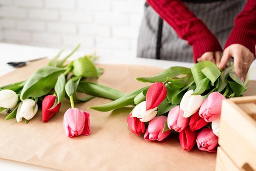 Valentine's Day and Women's Day. Small business. Woman florist making a bouquet of fresh colorful tulips