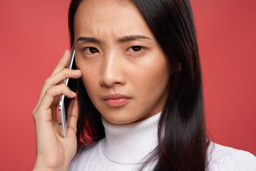 brunette with disgruntled expression talking on the phone technology emotions close-up. High quality photo