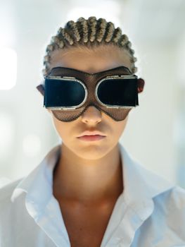 Fashionable woman with dreadlocks on her head and in 3D glasses of virtual reality on a light background. High quality photo