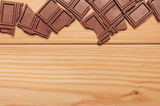 broken brown chocolate bar and background image texture top view. High quality photo