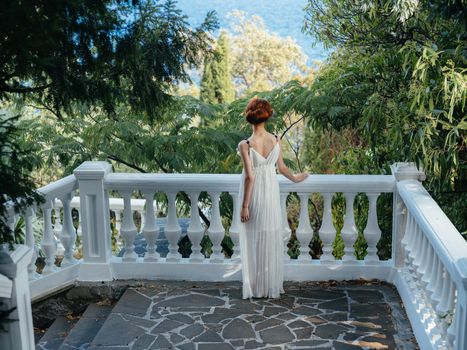 Beautiful woman white dress glamor green leaves summer Greece. High quality photo
