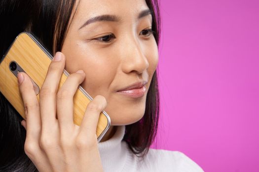 woman asian appearance phone communication internet lifestyle pink background. High quality photo