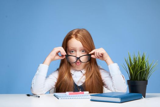 emotional girl doing homework at the table school learning childhood. High quality photo