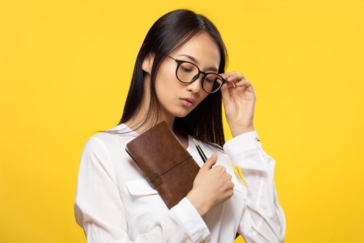 woman asian appearance executive notepad manager hand yellow background. High quality photo