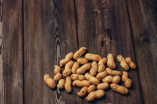 scattered peanuts in shells on a wooden table top view beer snack. High quality photo