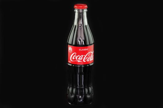 Coca cola. Glass bottle with Coca-Cola logo, close-up, isolated on a black background. Editorial image. Russia, Nizhny Novgorod 19.02. 2021. High quality photo