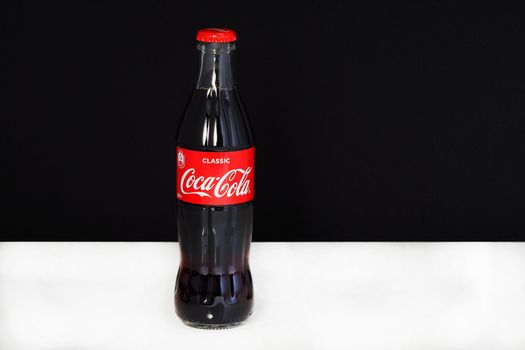 Coca cola in a glass bottle with the logo, isolated, on a black-and-white background. High quality photo. Editorial image. Russia, Nizhniy Novgorod 21.02.2021 G.