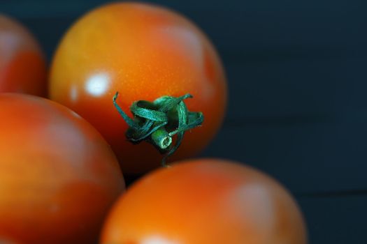 Red ripe cherry tomatoes on a black background close-up. High quality photo