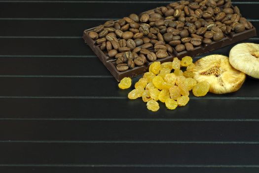 Dark or bitter chocolate with whole nuts, raisins and figs. Natural coffee beans as ingredients for. High quality photo