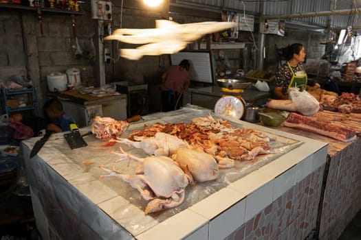 Street food market in Asia. Meat counter in the open air. Bird carcasses on ice in hot climates.