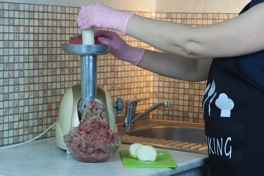 Cooking minced meat and onions on an electric meat grinder. High quality photo