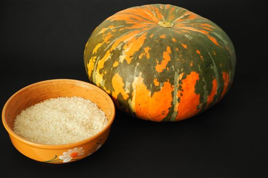 Round orange pumpkin with ingredients for cooking. Black background. High quality photo