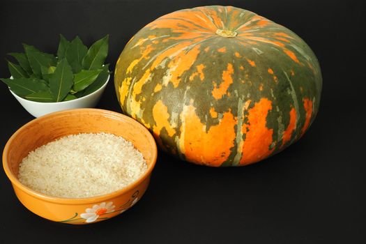 Round orange pumpkin with ingredients for cooking. Black background. High quality photo