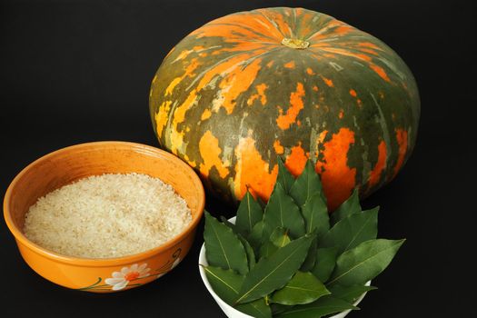 Round orange pumpkin with ingredients for cooking. Black background. High quality photo