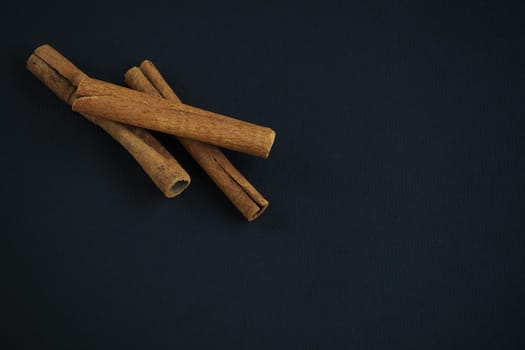 Ingredients and spices for pastries and drinks. Cinnamon sticks on a black background.