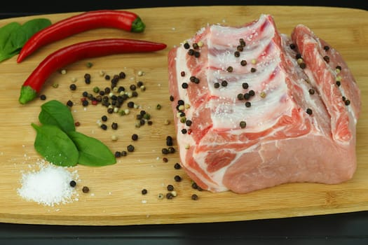 A piece of fresh raw meat on a bone with pepper and coarse salt. High quality photo