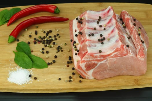 A piece of fresh raw meat on a bone with pepper and coarse salt. High quality photo