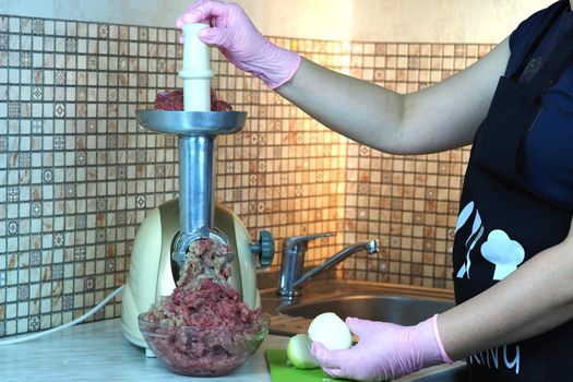 Cooking minced meat and onions on an electric meat grinder. High quality photo