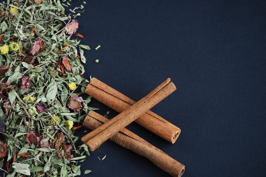 Dried cinnamon sticks and herbal tea on a black background. A quality image.